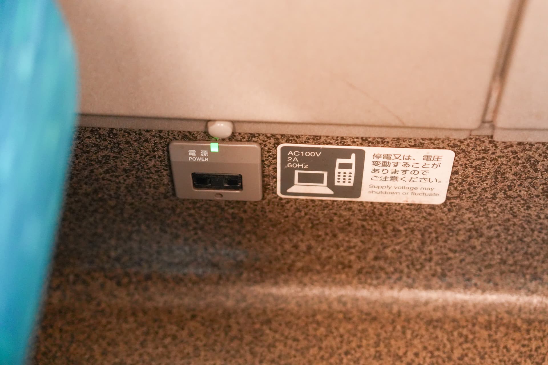 Outlet detail — AC 100V port under the window seat