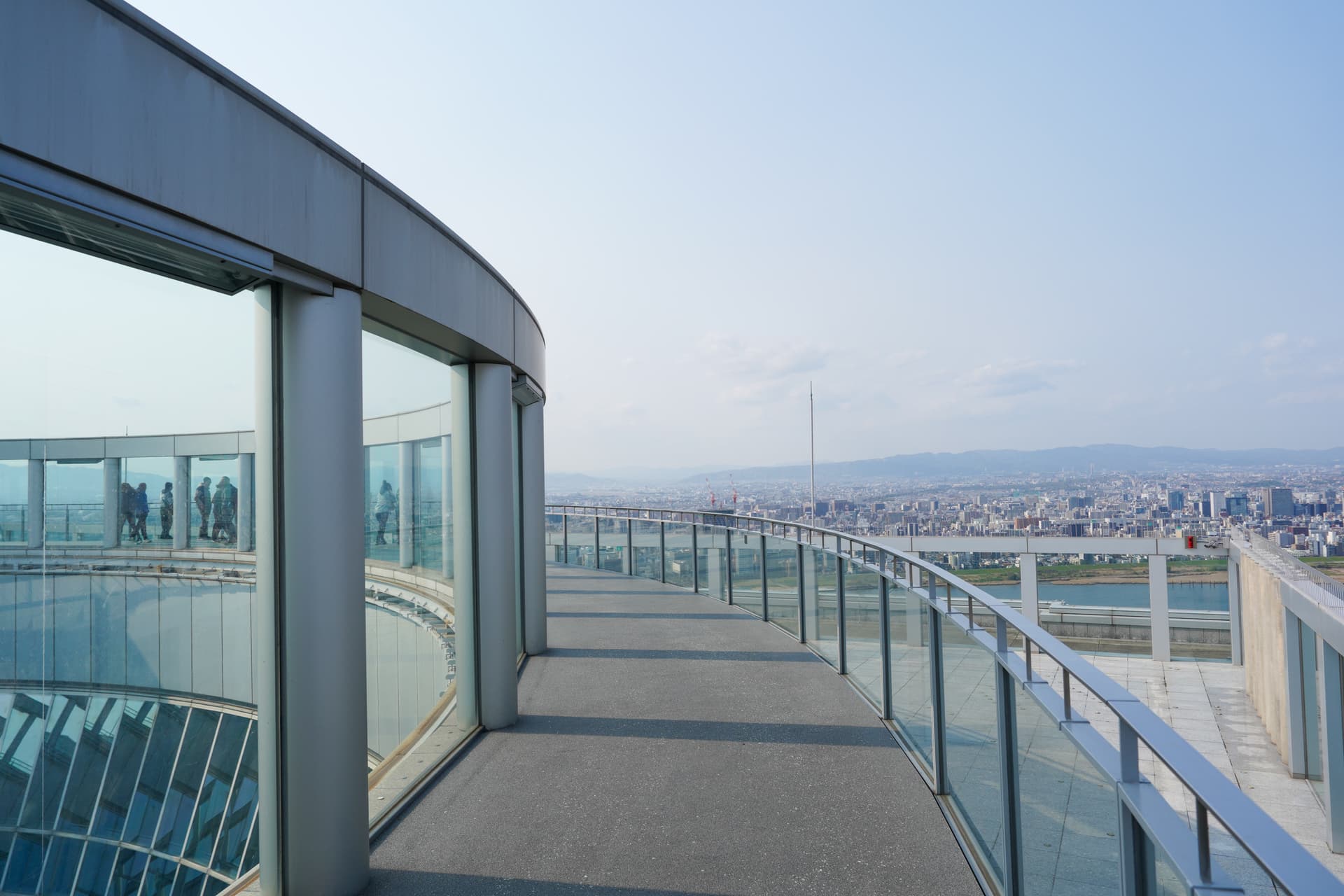 Open-air rooftop walkway at Umeda Sky Building with Osaka cityscape and river view