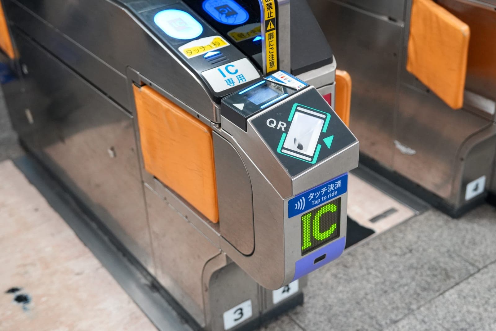 Osaka Metro gate close-up — combined IC tap-to-ride and QR scanner module