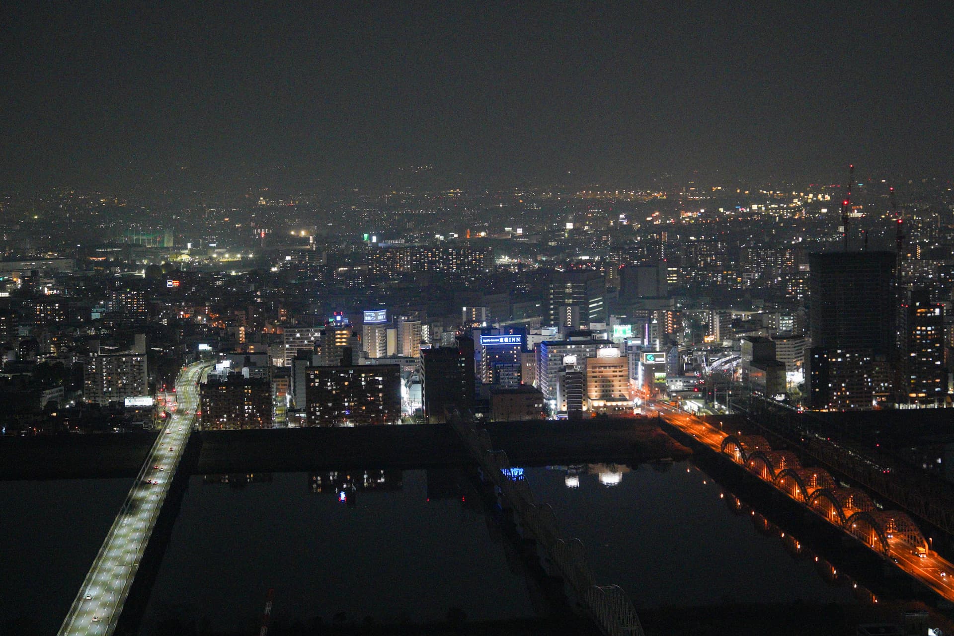 Osaka night skyline from the rooftop — river and city lights
