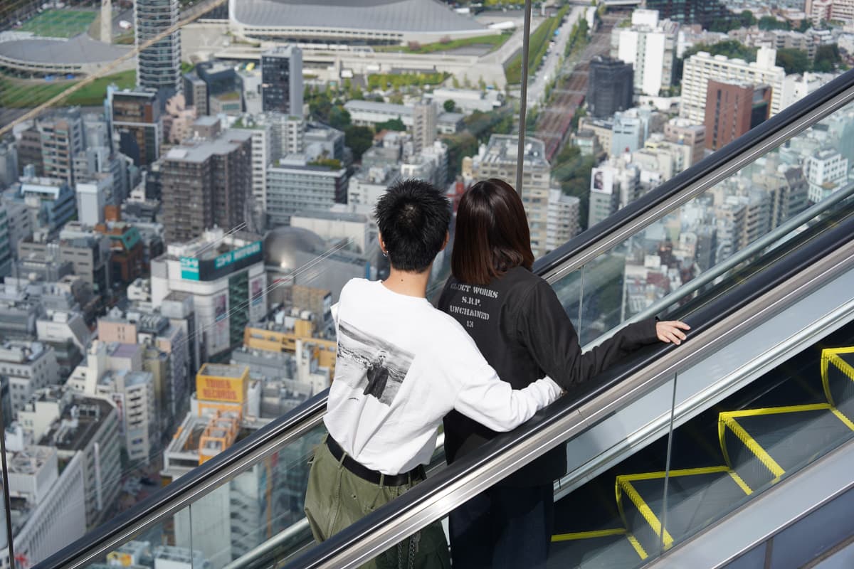 Escalator ride up to Shibuya Sky rooftop with city view