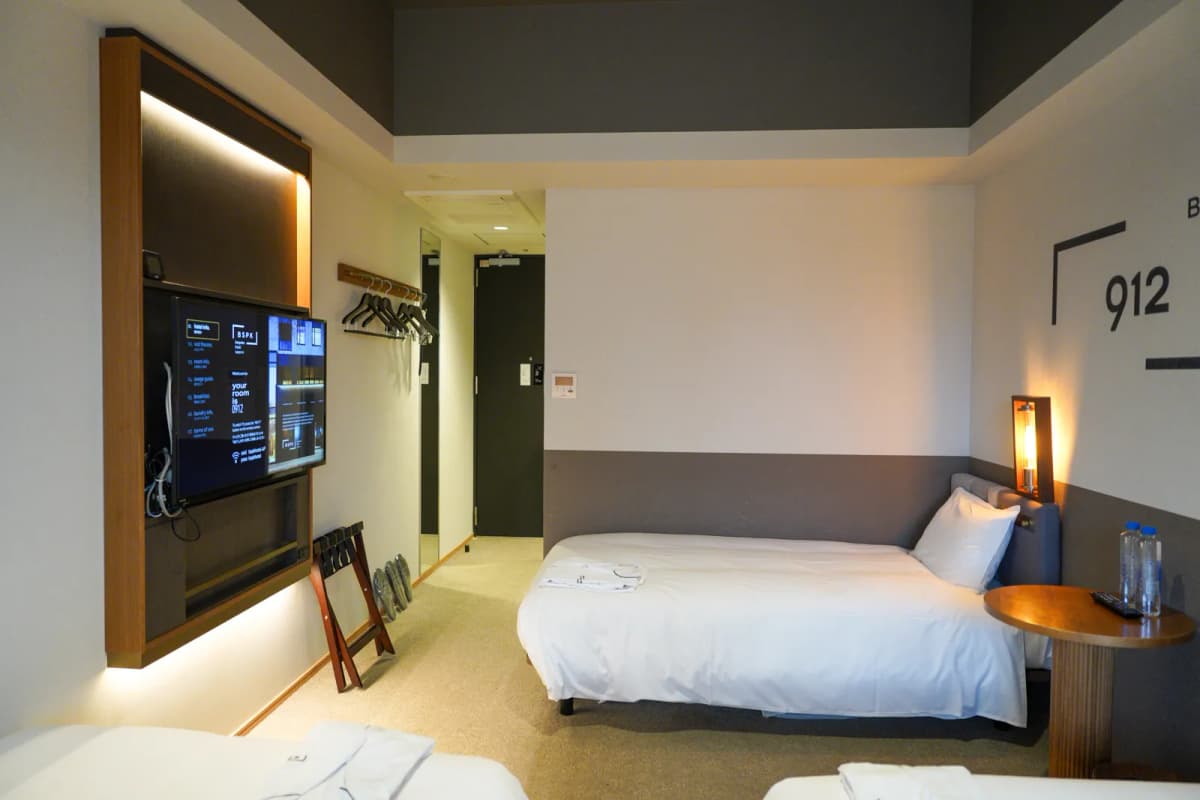 Bespoke Hotel triple room with a single bed against the wall and a wall-mounted TV