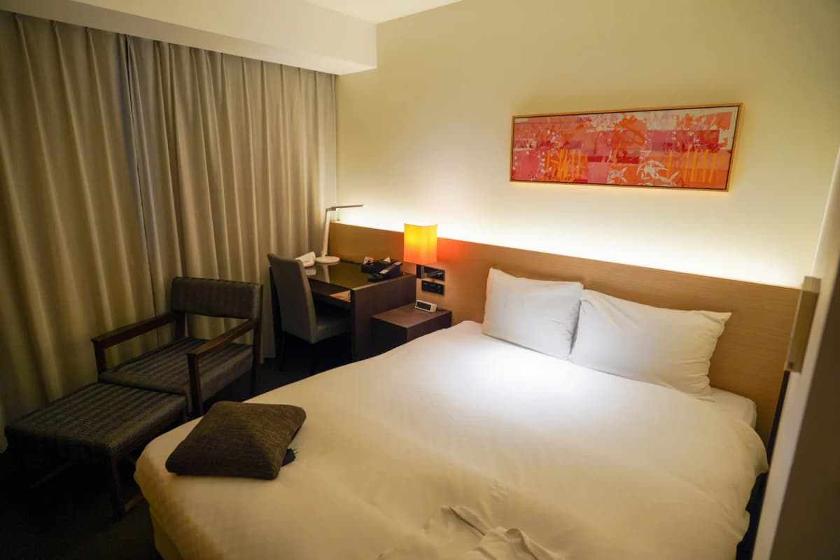 Bed and sofa in a room at Hotel Forza Hakataeki Chikushiguchi I