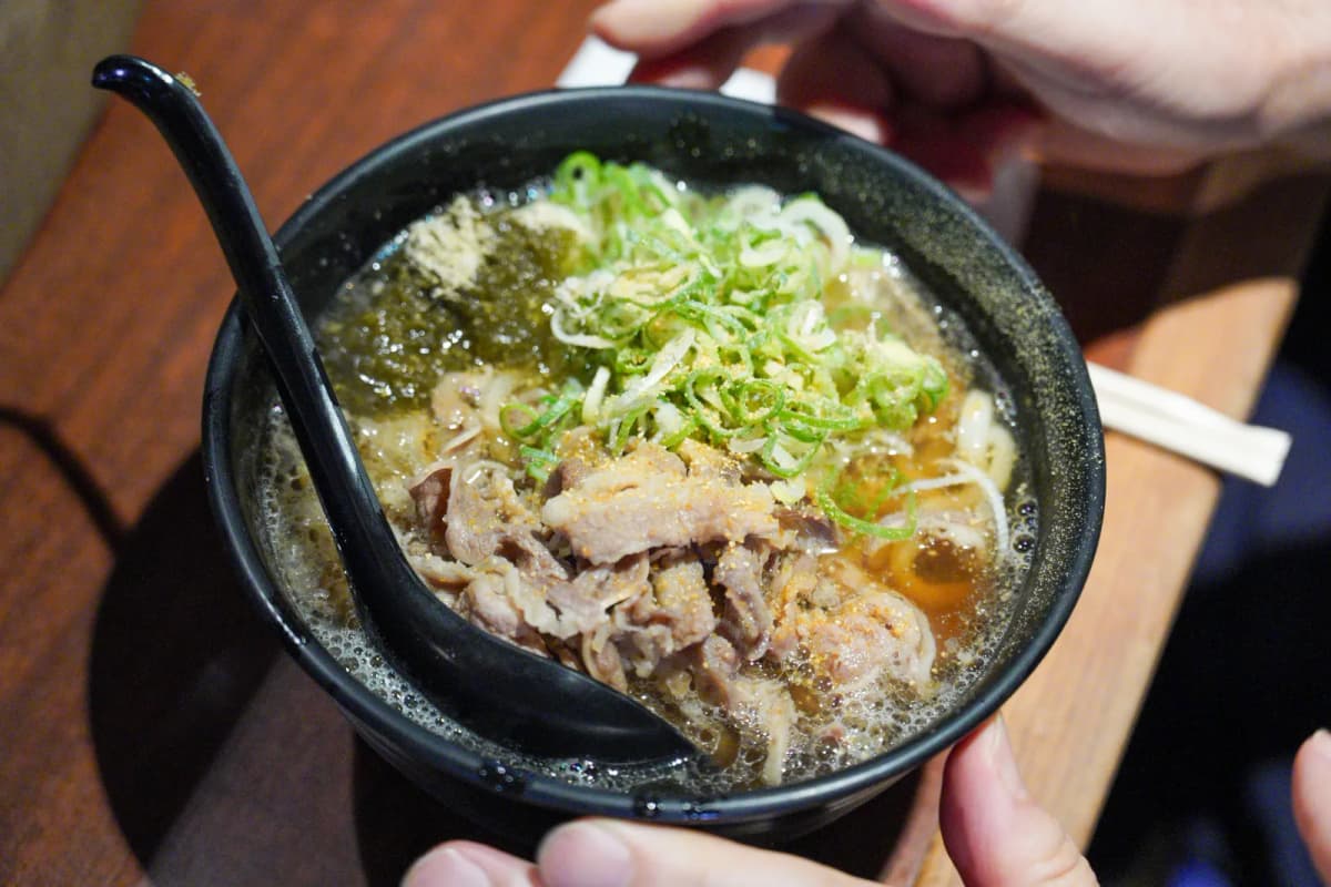 Kasu udon with beef and green onion in a black bowl at Kasuya Hozenji