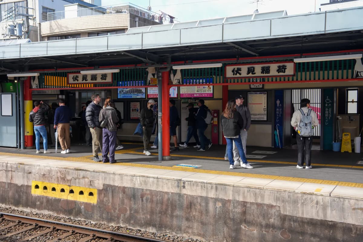 Fushimi-Inari Station platform with red pillars and the station name signs