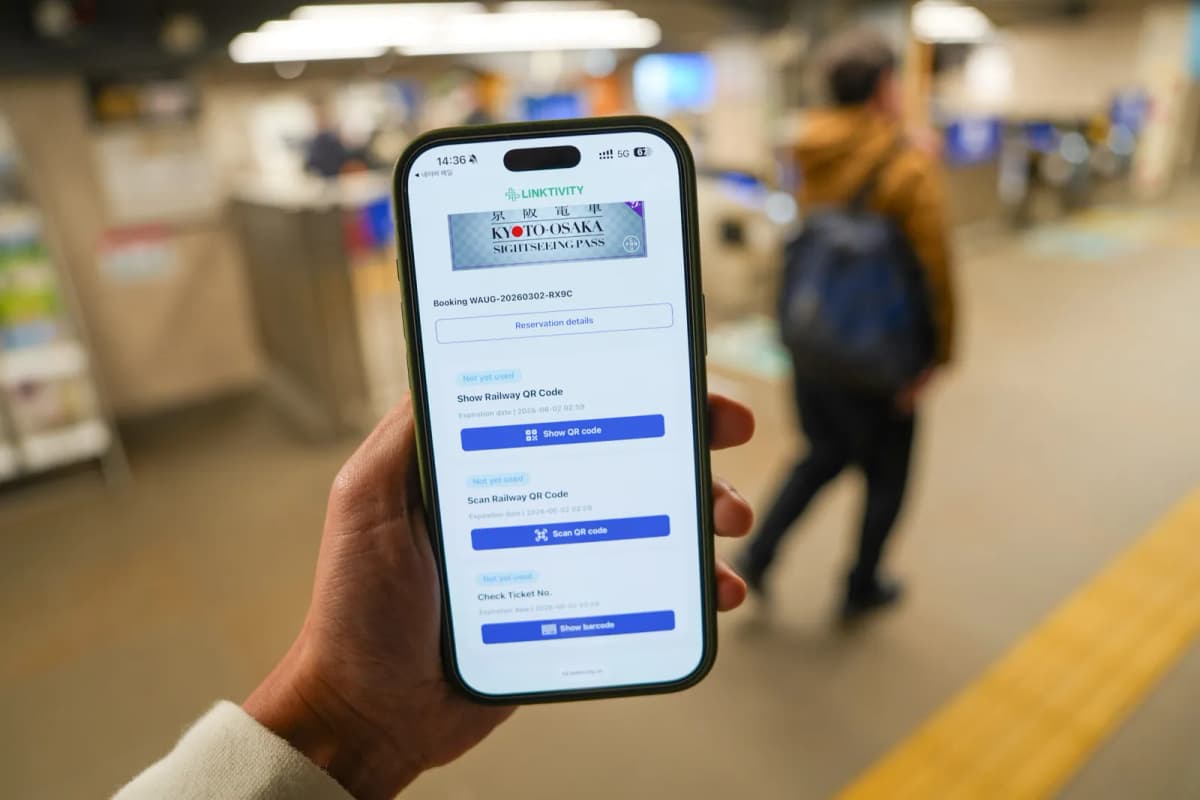 Smartphone showing the Kyoto-Osaka Sightseeing Pass digital voucher at a Keihan station