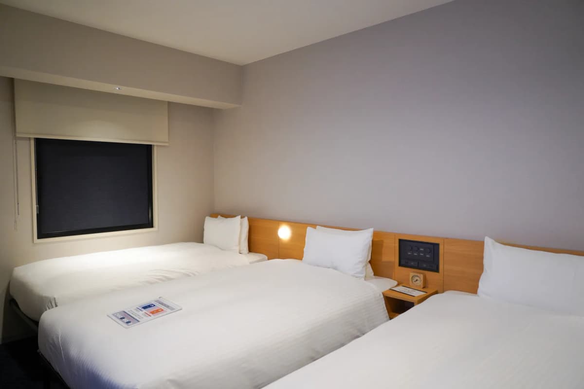 Guest room with three beds in a row at Sotetsu Fresa Inn Susukino