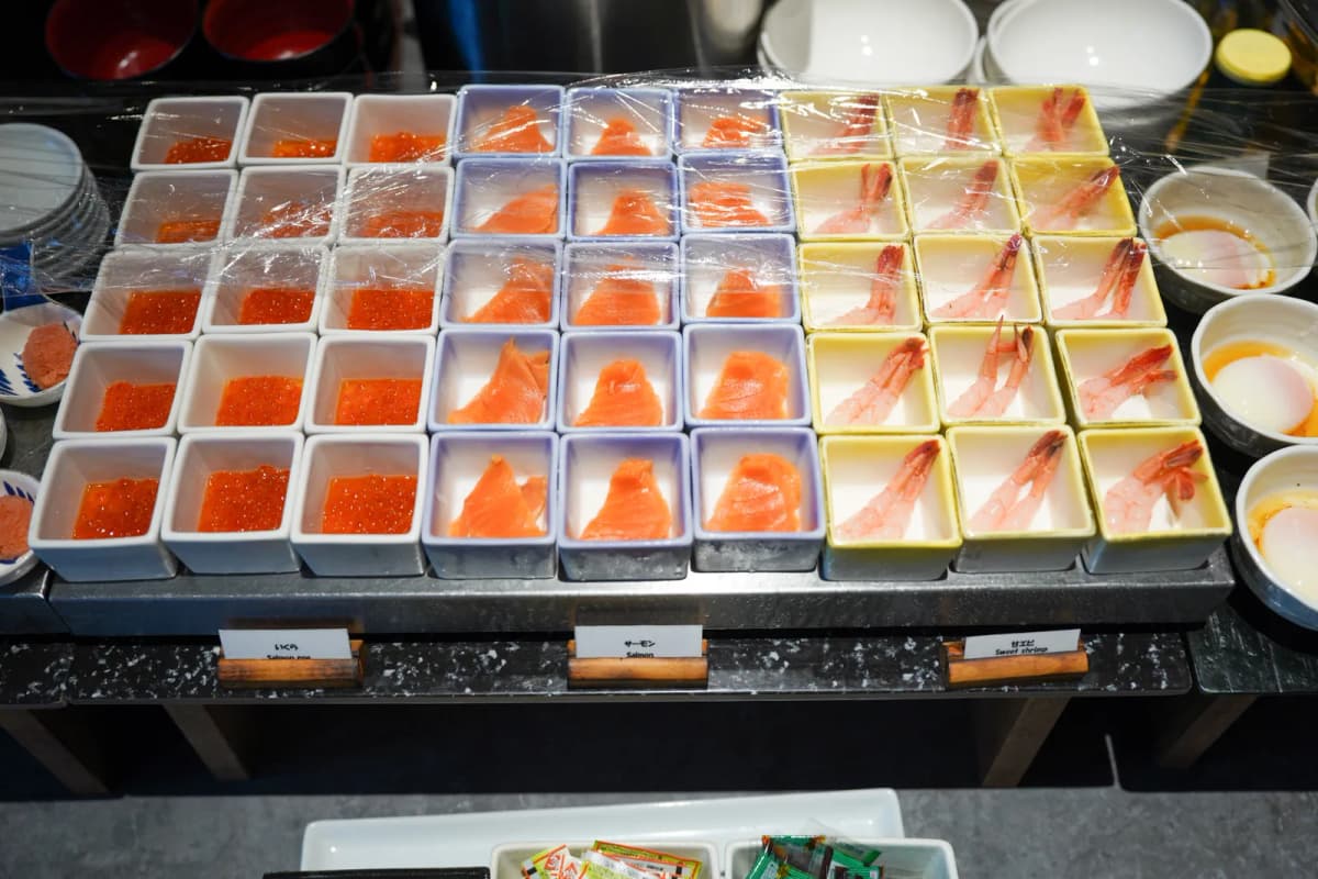 Salmon roe, salmon sashimi and sweet shrimp in small dishes at the Bespoke Hotel breakfast