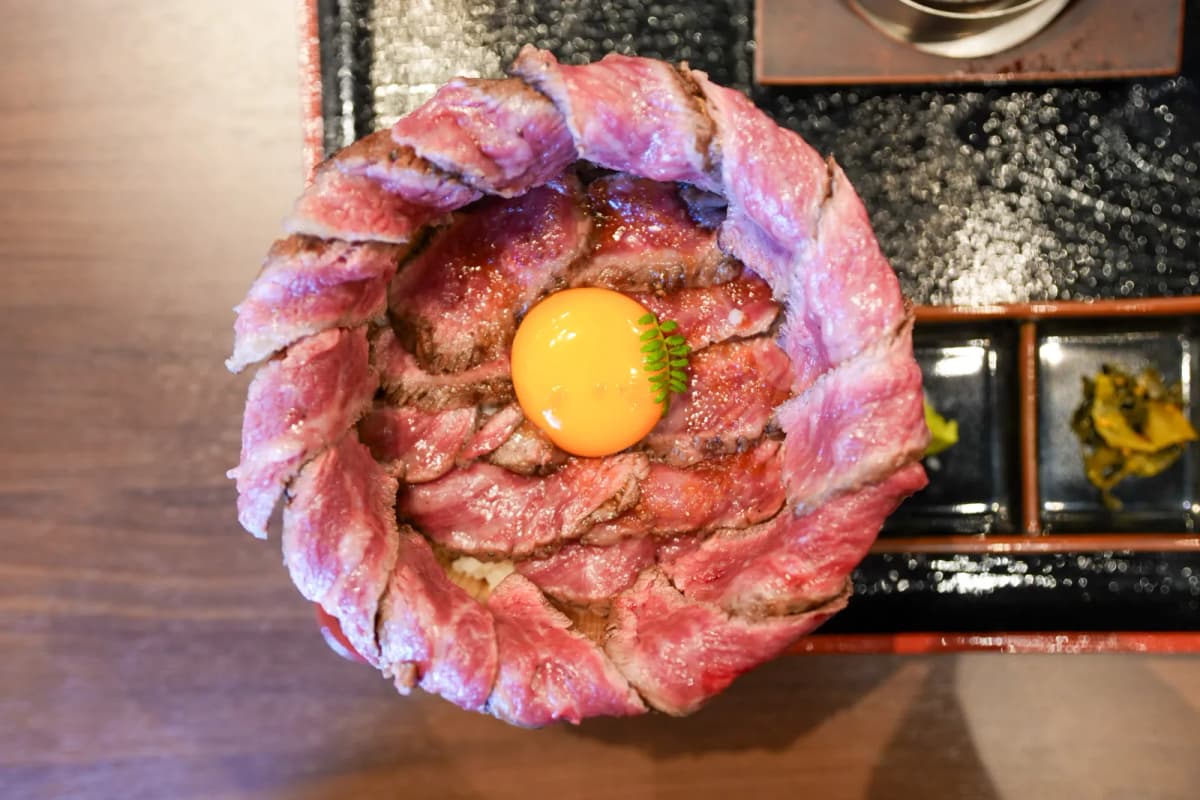 Wagyu mabushi with sliced beef piled around a raw egg yolk at Keika