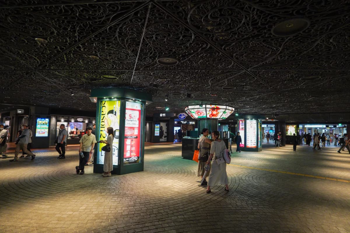 Walkway in Tenjin Underground Mall with pillar ads under the ornate ceiling